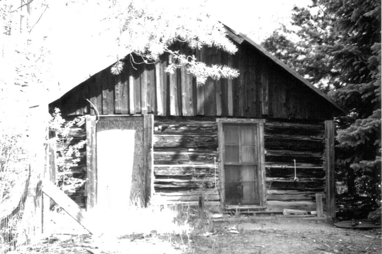 Antique black and white photo of log cabin