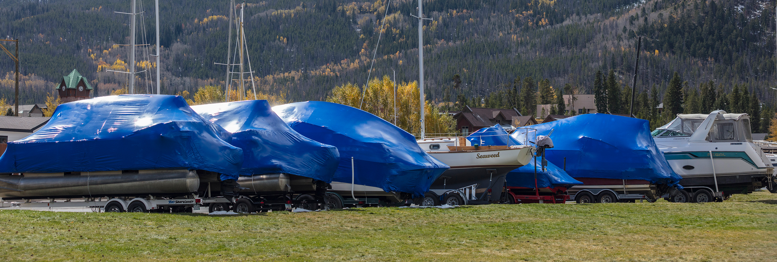 Wrapped boats on trailers in winter storage.