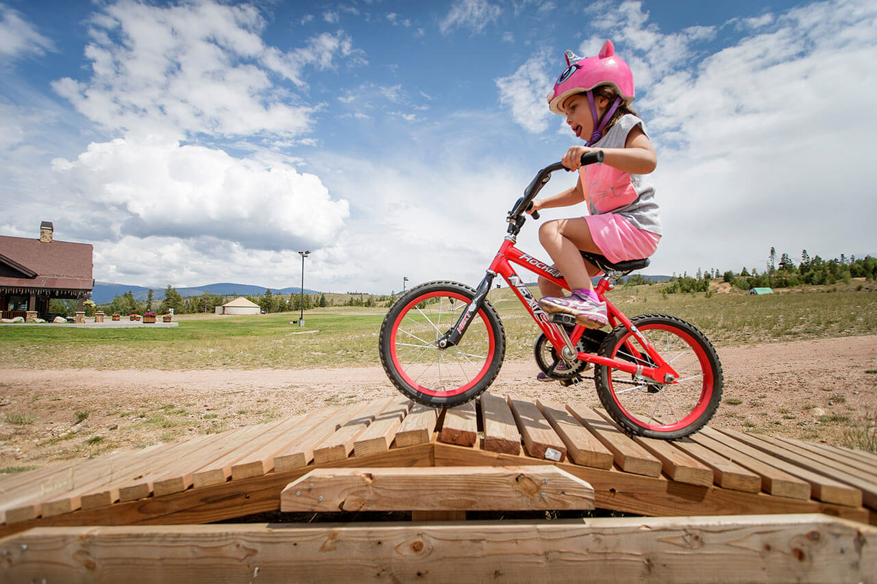 Girl on bike on wooden feature at Frisco Bike Park