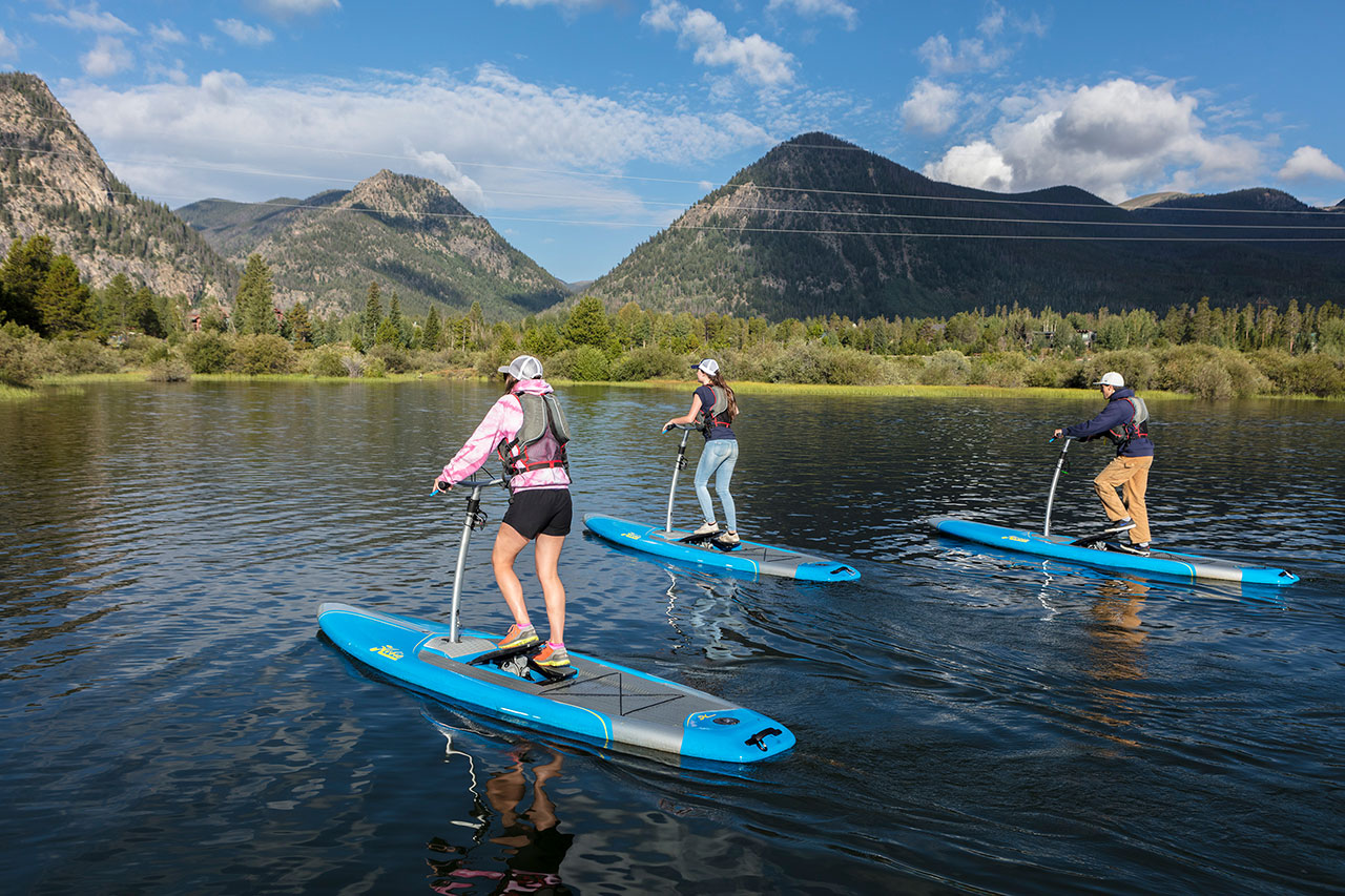 Three standup paddle boarders on Lake Dillon, Mt. Royal in background.