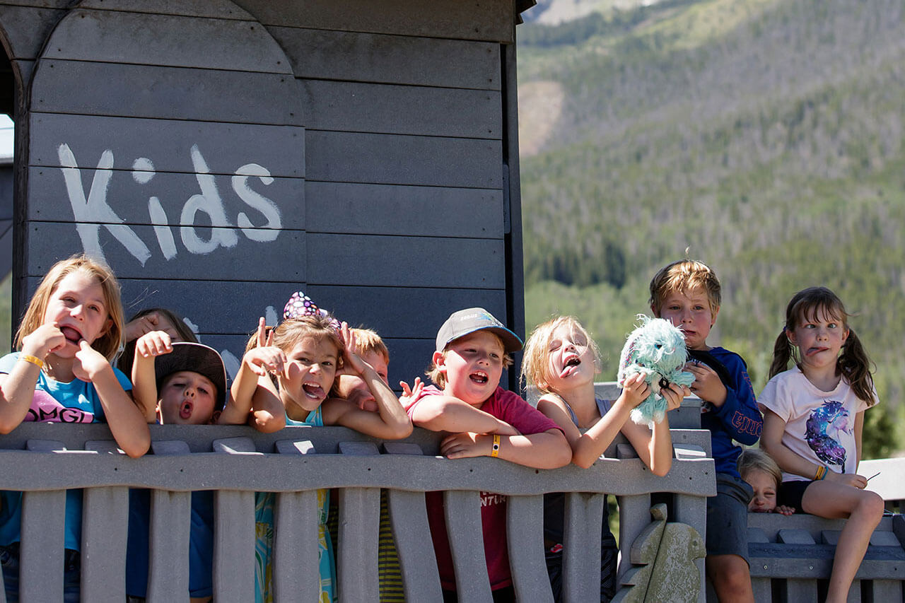 Group of kids posing on a deck.