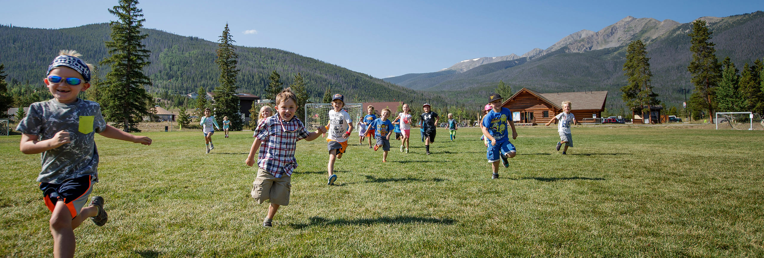 Young kids running through soccer field.