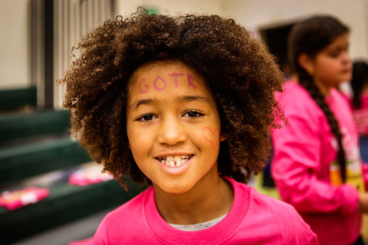 Close up of smiling young girl wearing pink.