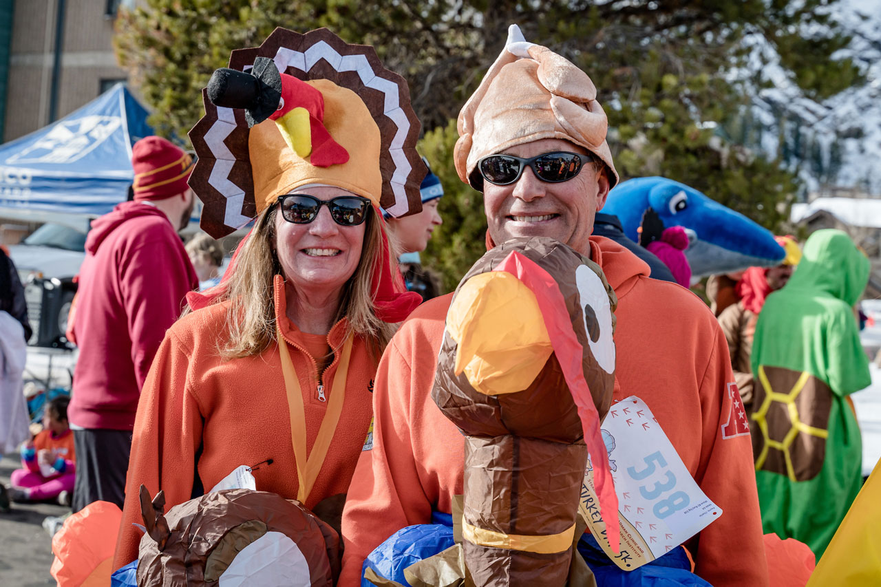 A man and a women wearing turkey costumes.