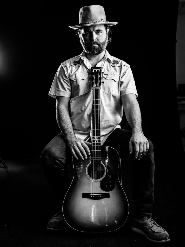 Black and white portrait of Andrew McConathy with guitar