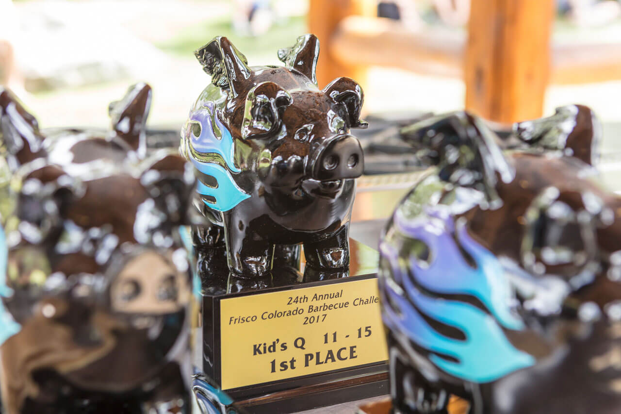 Close-up of pig-shaped trophies with plaques.