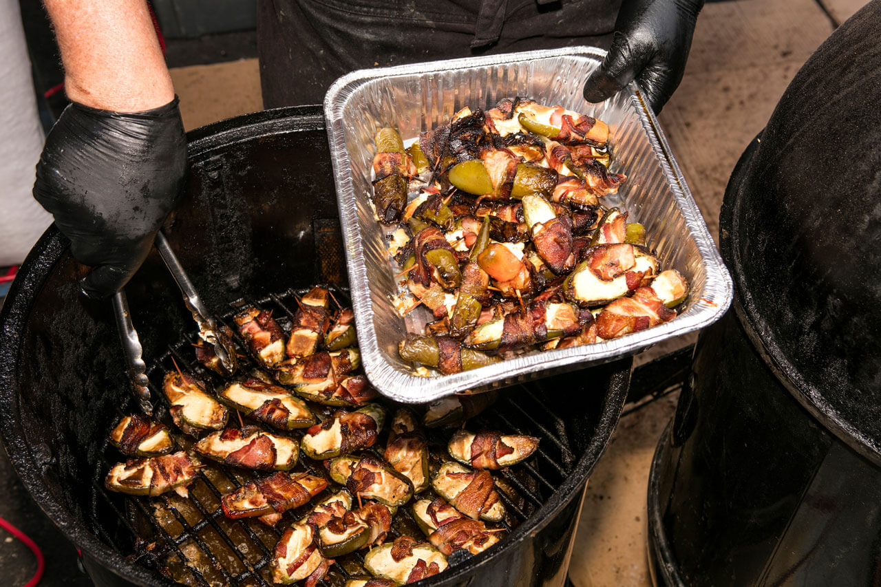 Close-up of bacon-wrapped jalapeno poppers on a tray.