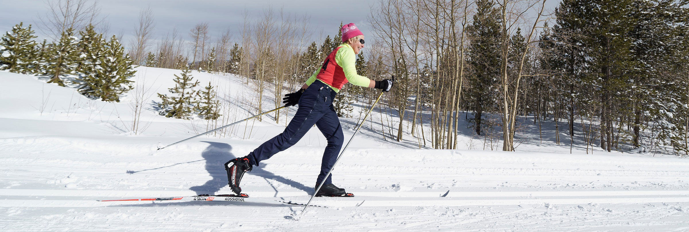 Woman Nordic skiing on groomed track.