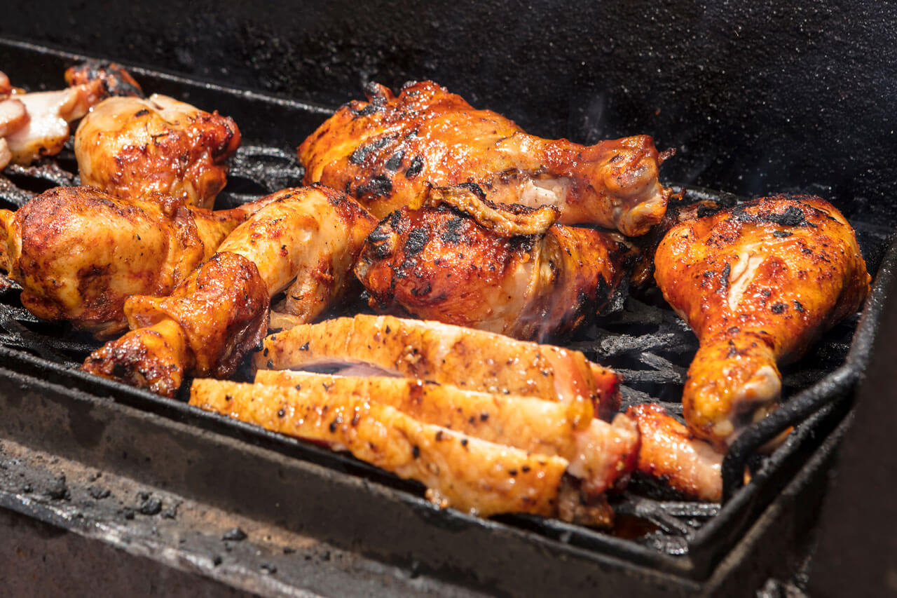 Close-up of chicken drumsticks on a grill.