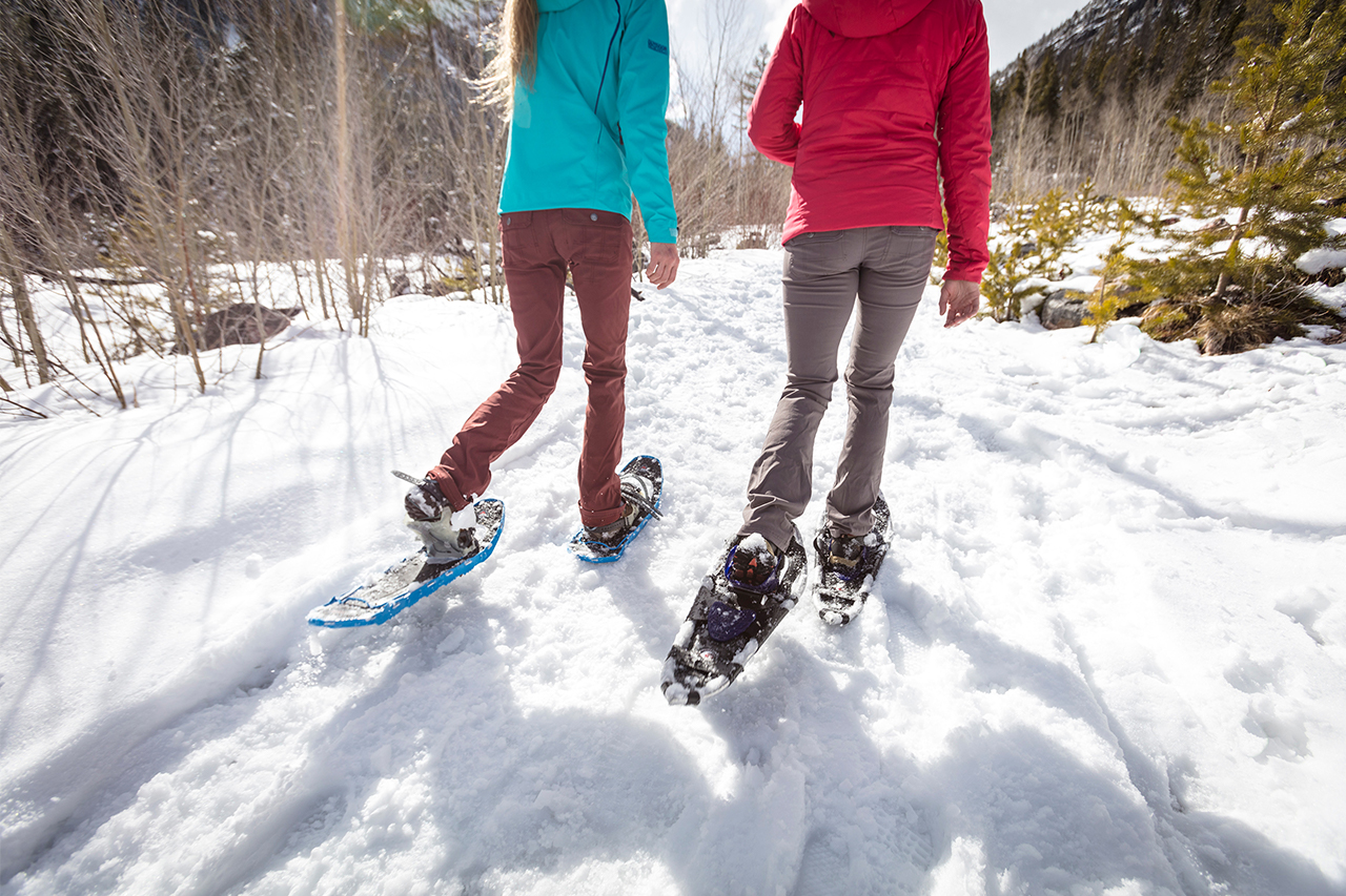 Closeup of two girls snowshoeing.