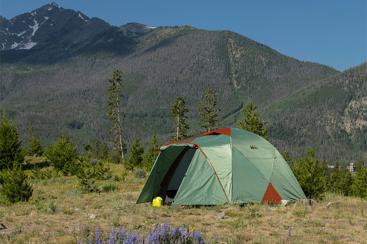 A green tent with Peak One in the background.