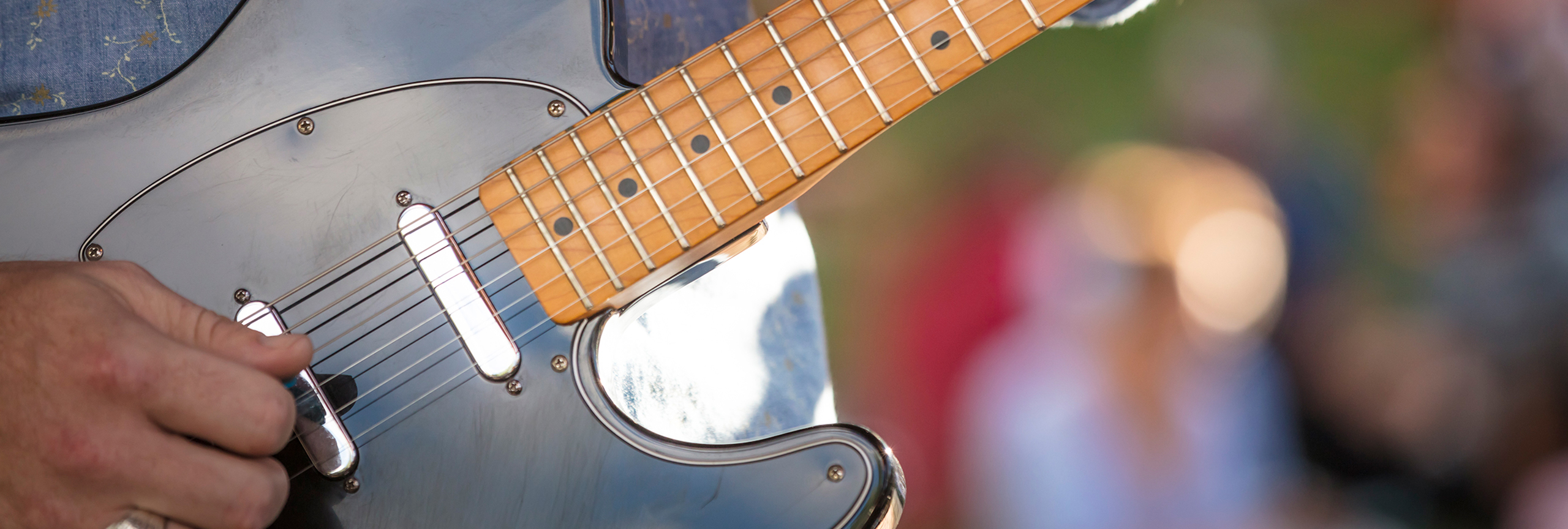 Closeup of man playing guitar.