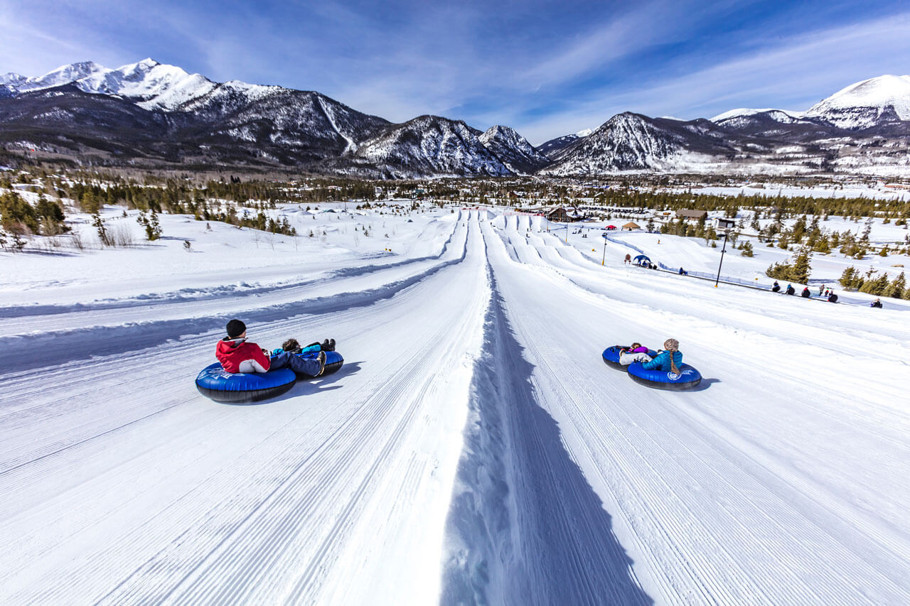 View from the top of the tubing hill at the Frisco Adventure Park with tubers in different lanes