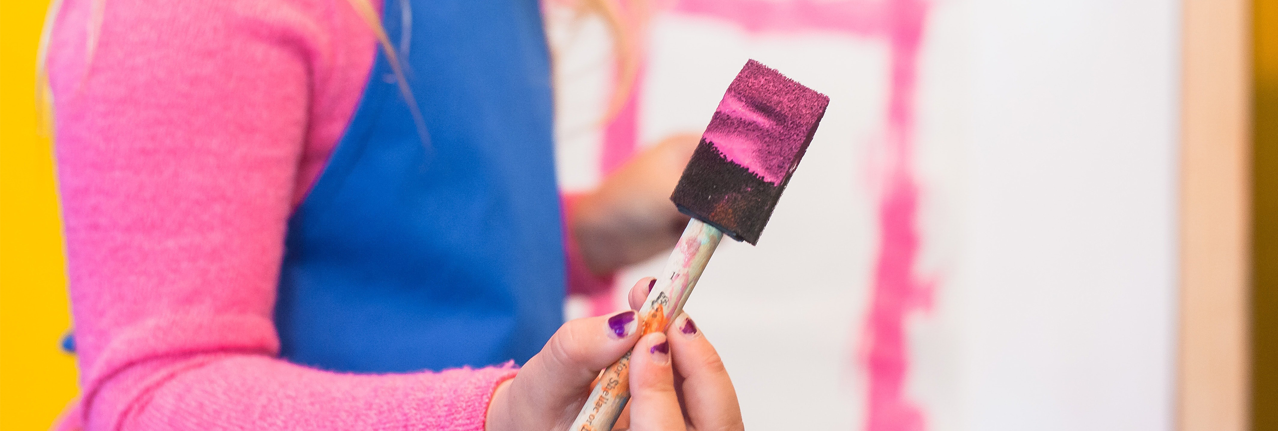Closeup of foam paintbrush with pink paint.
