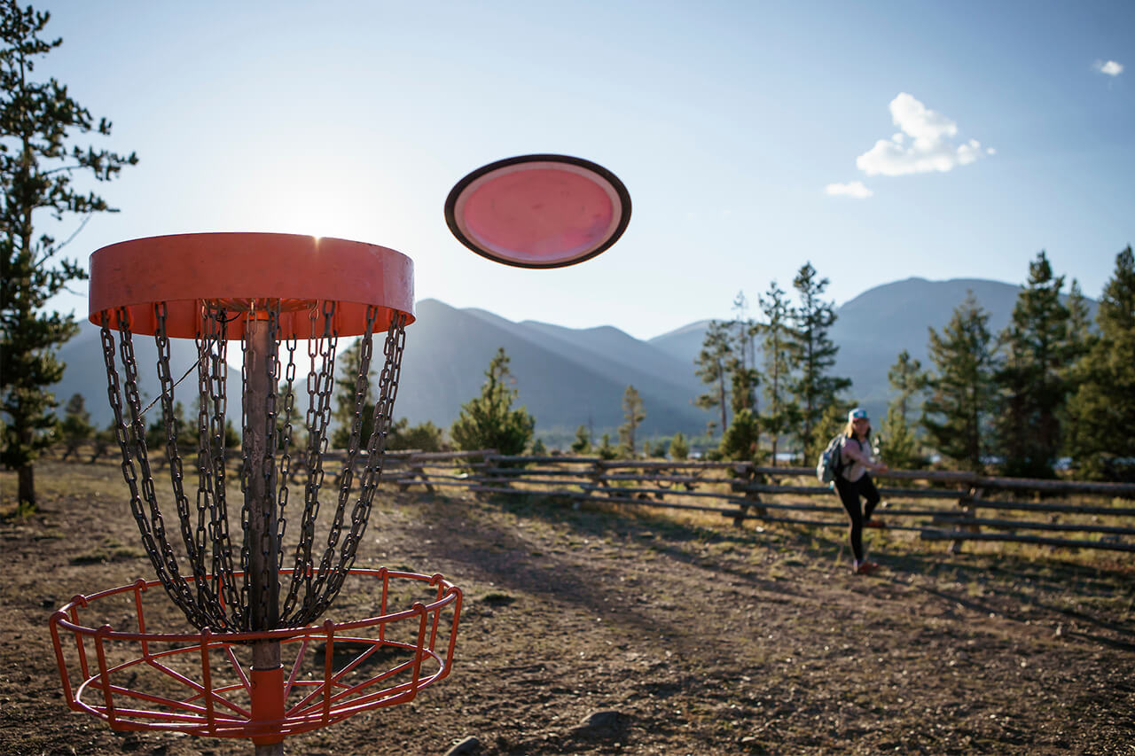 Close of up disc golf basket with disc flying towards it at Peak One Disc Golf Course in Frisco