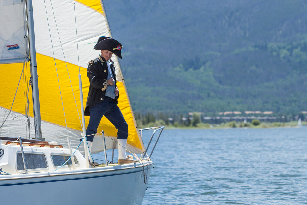 Man in colonial costume on a sailboat on Lake Dillon.