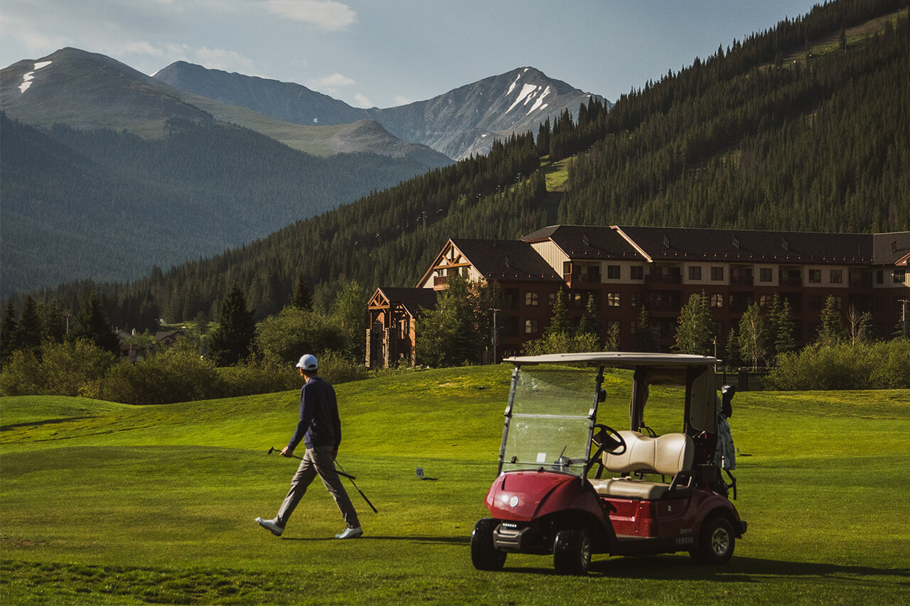 A golfer walking away from a red golf cart at the Copper Creek golf course.