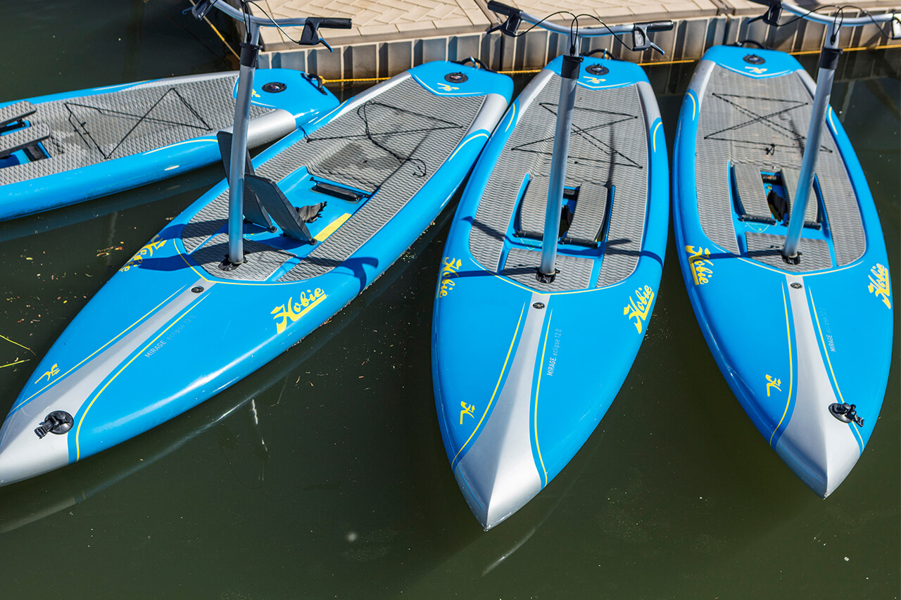Four blue paddle boards at a dock at the Frisco Bay Marina.
