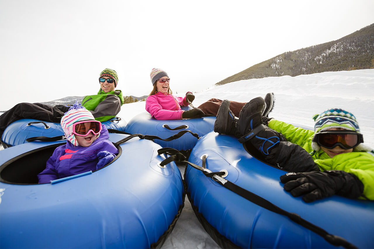 Family of four in tubes on tubing hill at Frisco Adventure Park