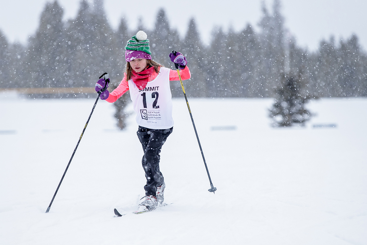 Young girl Nordic skiing on a snowy day.