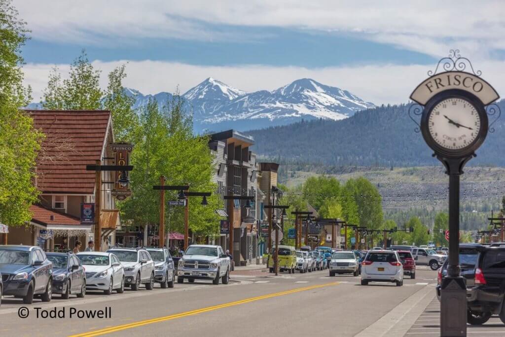 View of main street with tall, snowy peaks beyond.