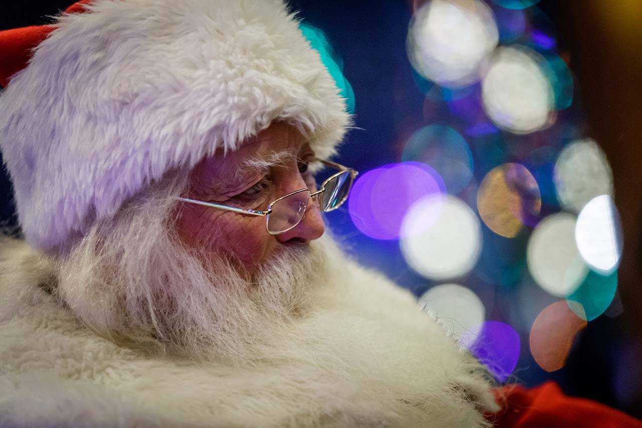 Close up of Santa's face with purple and teal lights in the background