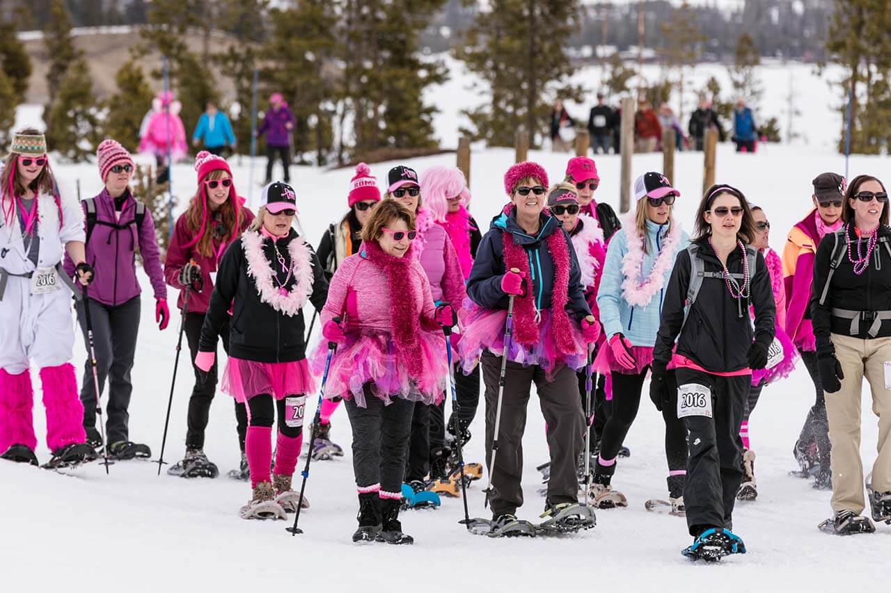 Group of women dressed in pink snowshoeing at Snowshoe for the Cure event