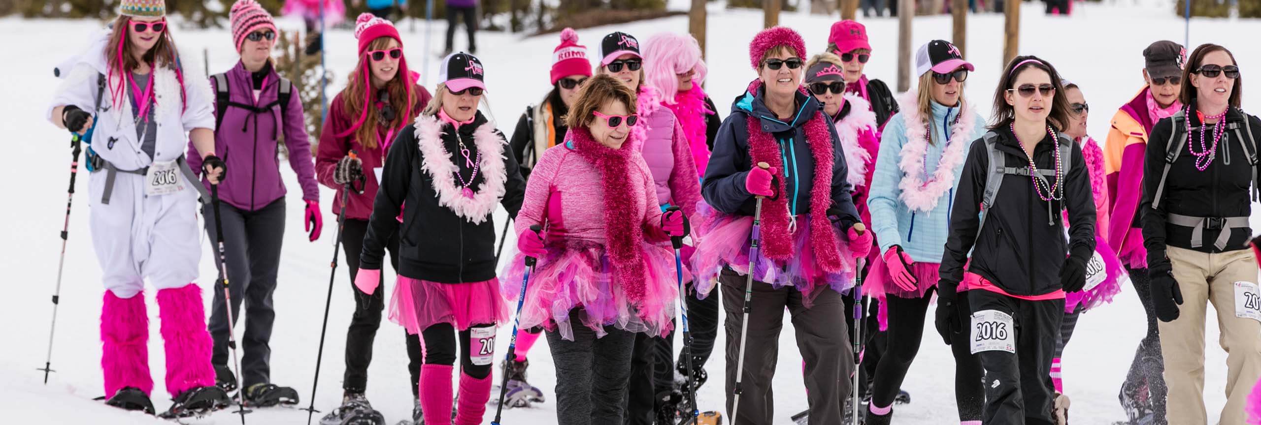 Group of women dressed in pink snowshoeing at Snowshoe for the Cure event