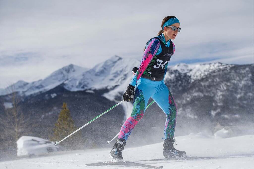 Woman skate skiing in Gold Rush Nordic Races with Peak One in background