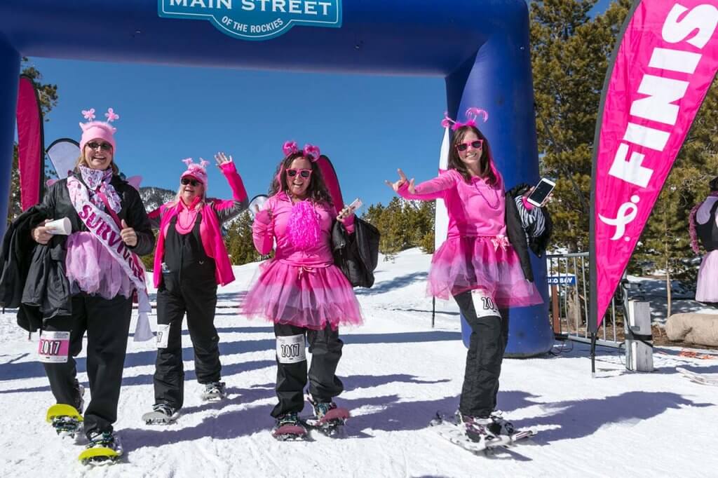 Grow up women dressed in pink wearing snowshoes