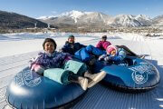 Family of four in tubes at top of tubing hill in winter in Frisco