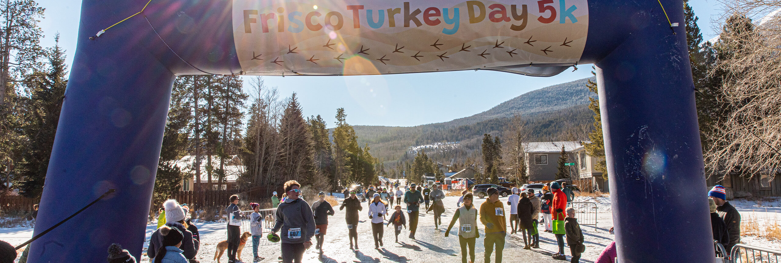 Runners under the Turkey Day 5K timing arch