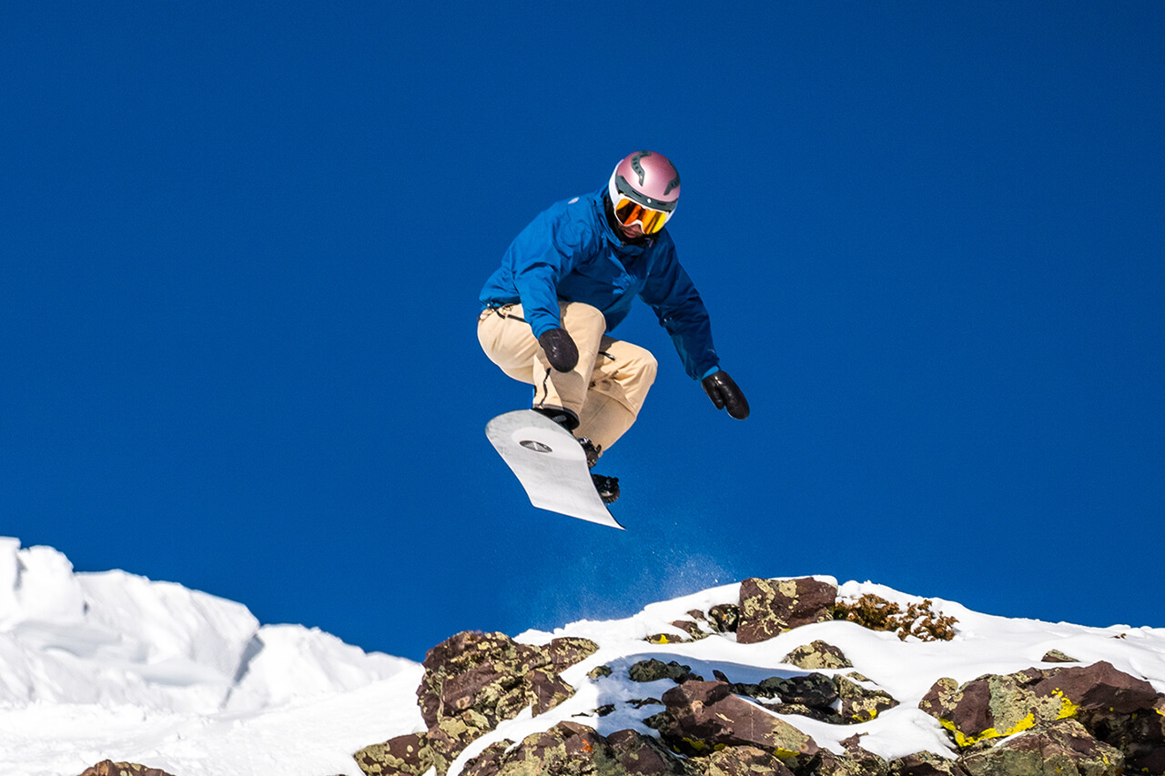 Snowboarder jumping off rock at Copper at IFSA Freeride Tour