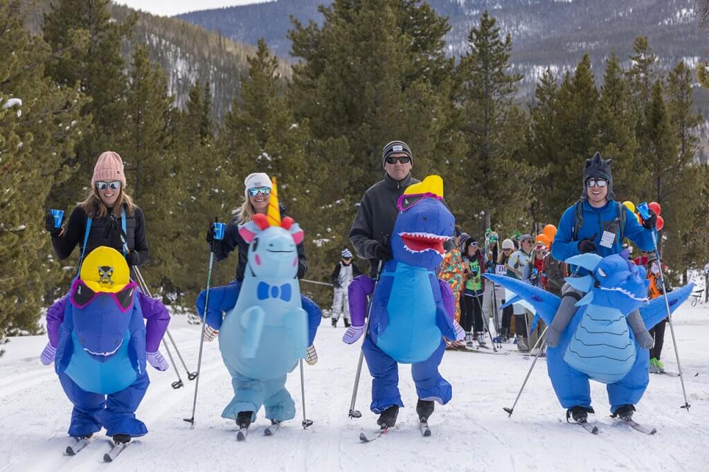 Group on Nordic ski in inflatable dinosaur costumes at Frisco BrewSki