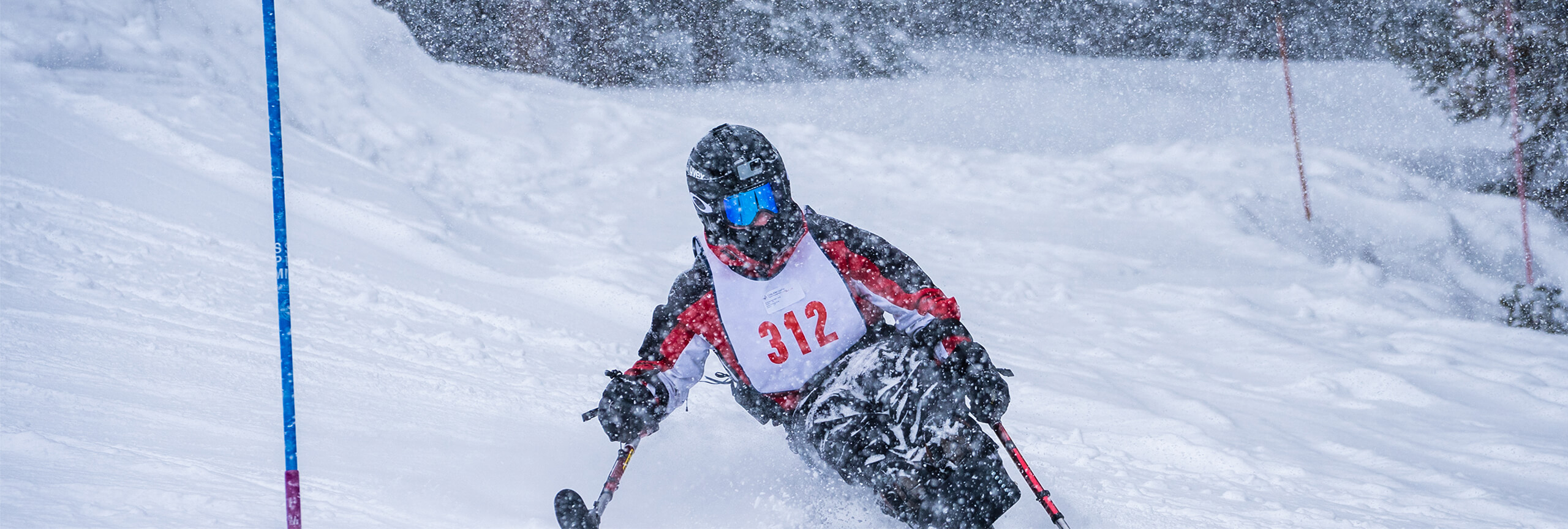 Sit skier skiing in powder at Special Olympics at Copper Mountain
