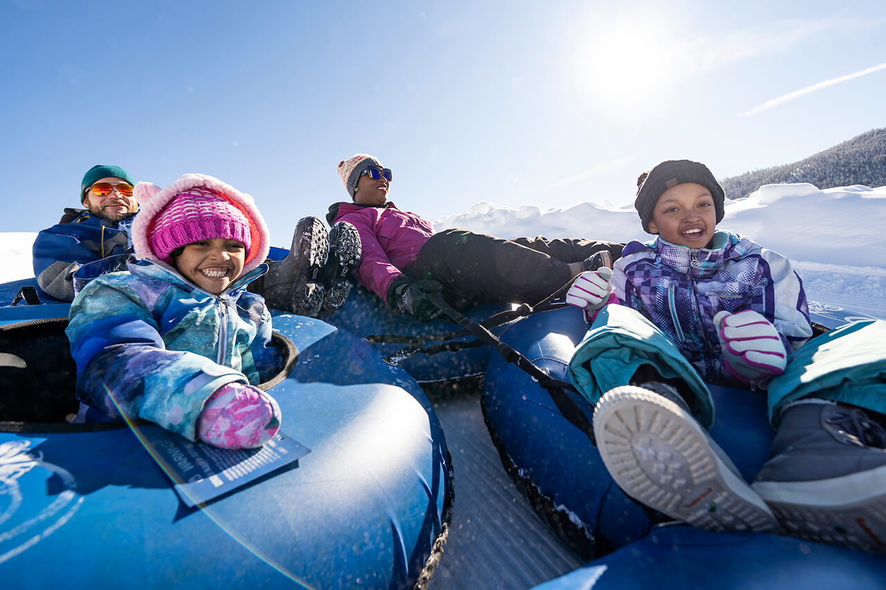 Parents and two girls tubing at Frisco Adventure Park